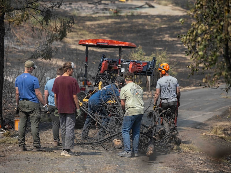 Des jeunes gens et des dirigeants du pieu du mont Spokane (Spokane, Washington) aident à déblayer les débris d'un quartier endommagé par des feux de forêt à Spokane (Washington), le lundi 3 août 2026.