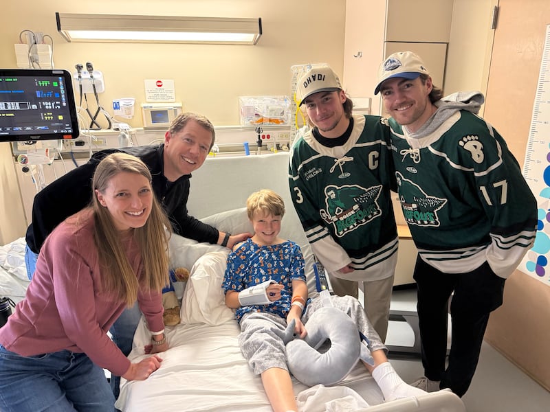 Nate Cooper, 9 ans, au centre, le fils d'Allie et Lee Cooper, à gauche, reçoit la visite des joueurs de hockey des Idaho Steelheads Nick Canade et Ty Pelton-Byce de l'équipe de hockey des Idaho Steelheads à l'hôpital pour enfants St. Luke's à Boise, Idaho, le 10 mars 2026.