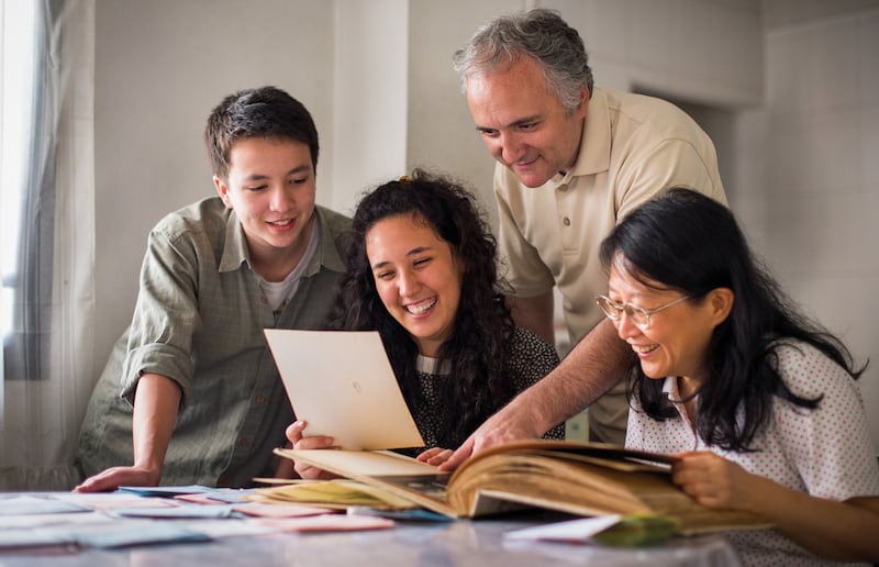 Une famille consultant ensemble des documents d'histoire familiale.