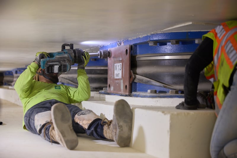 Des ouvriers retirent des boulons de l'un des 98 isolateurs de base situés à 20 pieds sous le temple de Salt Lake à Salt Lake City le jeudi 25 juin 2026.