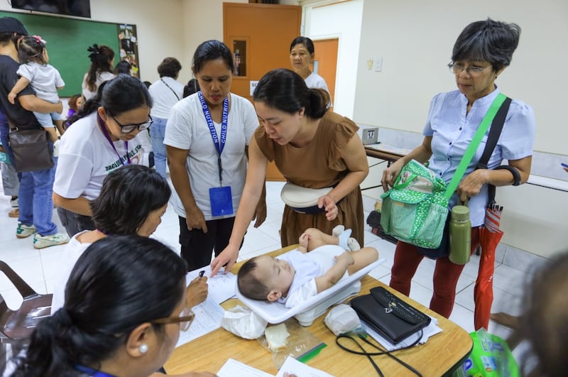 Un enfant est pesé lors d'un dépistage de santé et de nutrition à Tacloban City, aux Philippines, le 19 septembre 2026.