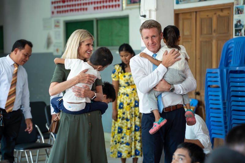 Le président général des Jeunes Gens, Timothy L. Farnes, à droite, et son épouse, sœur Linsey Farnes, tiennent de jeunes enfants lors de leur visite au Centre national pour les nourrissons et les enfants au Cambodge le 23 mai 2026.