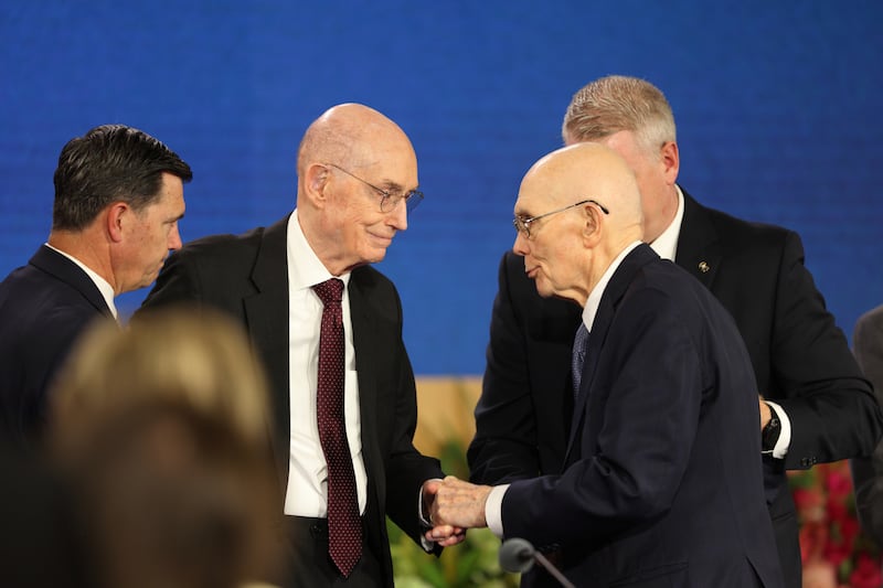 Le président de l'Église Dallin H. Oaks, au centre à droite, serre la main du président Henry B. Eyring, premier conseiller dans la Première Présidence.