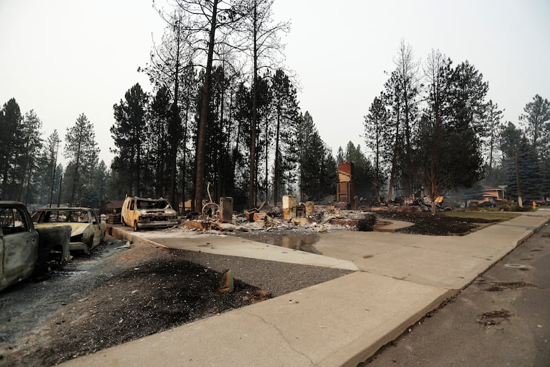 Des débris sont éparpillés autour de structures incendiées après un incendie de forêt, le dimanche 2 août 2026, à Spokane (Washington).