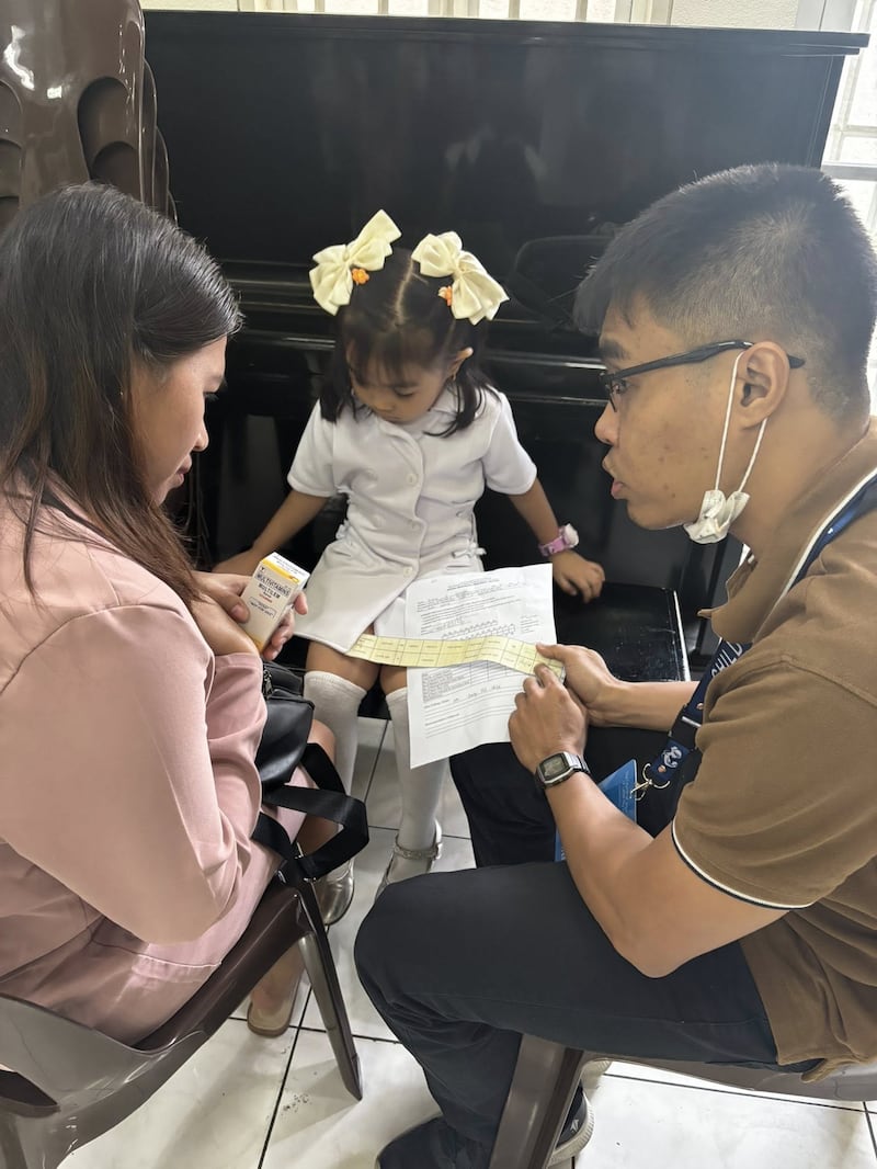 Une travailleuse de la santé parle à une mère de la croissance de sa fille lors d'un dépistage du Programme de nutrition infantile tenu au centre de pieu de Caloocan, aux Philippines, le 24 janvier 2026.