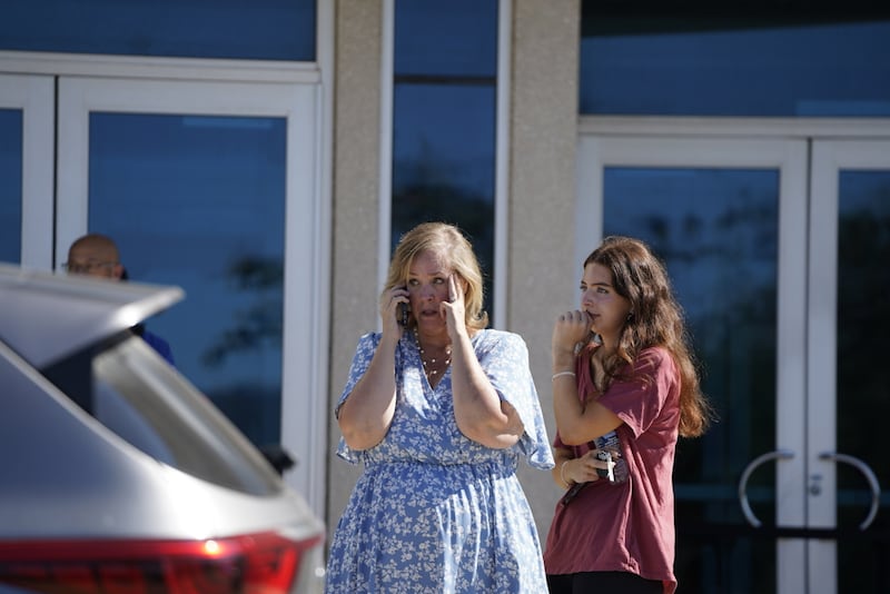 Des personnes se rassemblent dans une zone de regroupement après un incident impliquant un tireur actif et un incendie à L'Église de Jésus-Christ des Saints des Derniers Jours à Grand Blanc, dans le Michigan, le dimanche 28 septembre 2025.