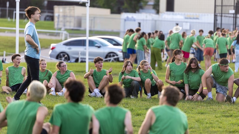 Des jeunes sont assis et debout sur un terrain au début d'une activité lors d'une conférence FSY à Calgary, en Alberta (Canada), en juillet 2026.