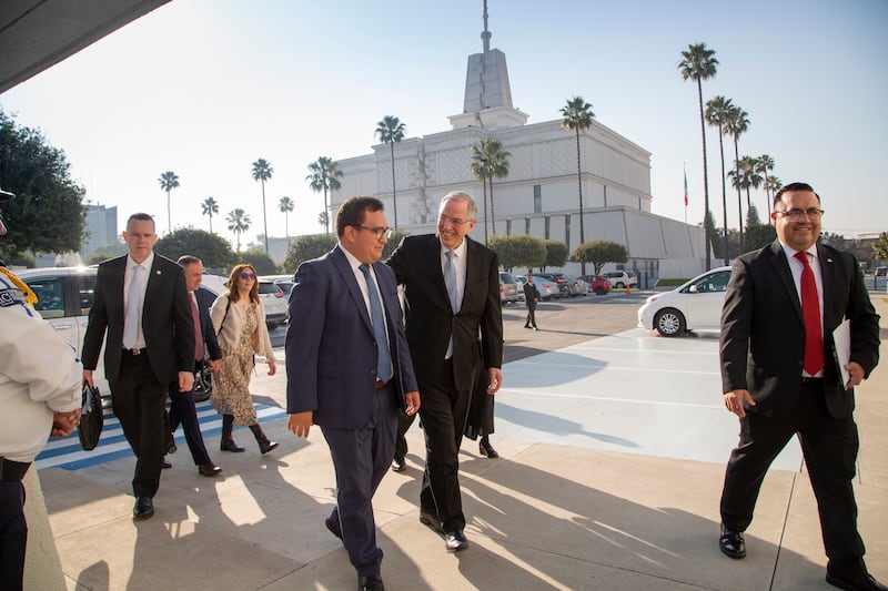 Avec le temple de Mexico (Mexique) en arrière-plan, le frère Neil L. Andersen, du Collège des douze apôtres, discute avec un membre tout en se rendant à une réunion à Mexico (Mexique), le 22 novembre 2025.