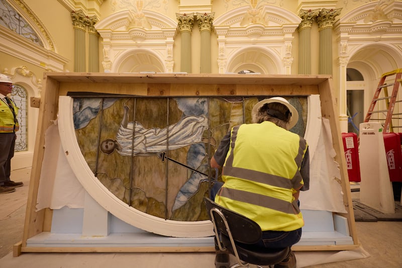 Un ouvrier nettoie une pièce de vitrail représentant Adam et Ève lors de l'installation le mardi 21 avril 2026, à Salt Lake City. L'œuvre d'art se trouvera dans la salle céleste du temple de Salt Lake.