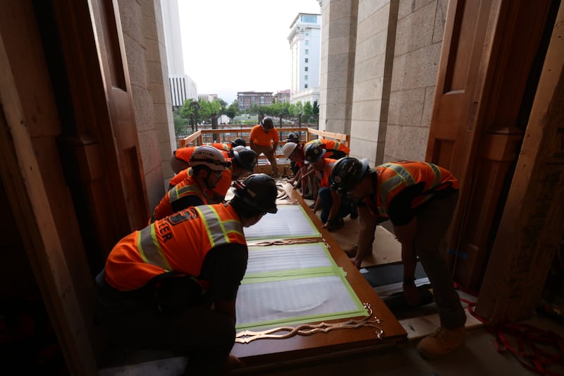 Des ouvriers préparent les portes est du temple de Salt Lake à être hissées en place le mardi 23 juin 2026.