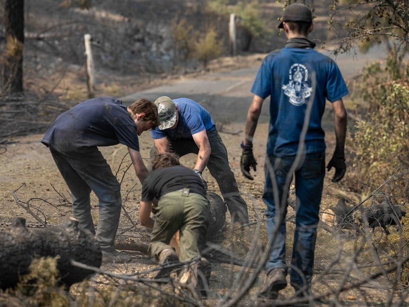 Des jeunes gens et des dirigeants du pieu de Mount Spokane (Spokane, Washington) aident à déblayer les débris dans un quartier endommagé par des incendies de forêt à Spokane (Washington), le lundi 3 août 2026.