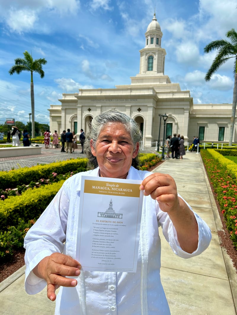 Betty Antonia Castro Torres tient une carte avec les paroles du cantique « L'Esprit du Grand Dieu » devant le temple de Managua (Nicaragua) après la consécration à Managua (Nicaragua), le dimanche 18 octobre 2026.
