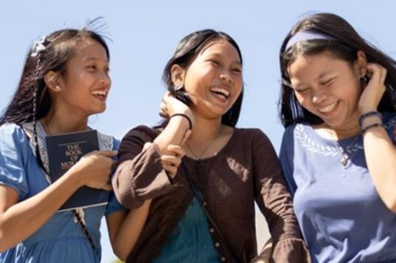 Trois jeunes filles discutent ensemble a l'exterieur.