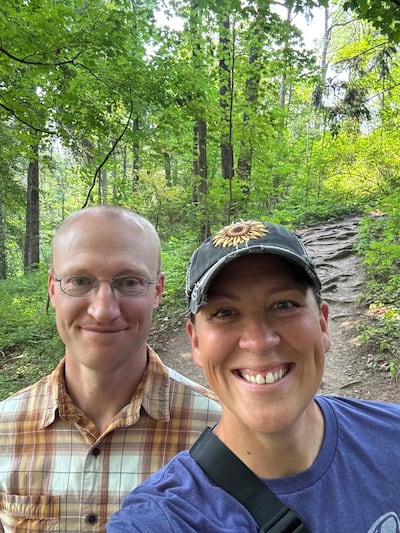 Glenn et Erica Nielson se tiennent dehors ensemble devant un sentier de terre.