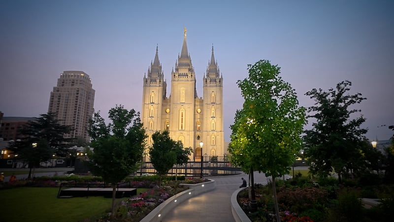 Juste après le lever du soleil le mardi 23 juin 2026, des ouvriers ont replacé les portes en bois rénovées dans leurs arches respectives sur le côté est du temple de Salt Lake.