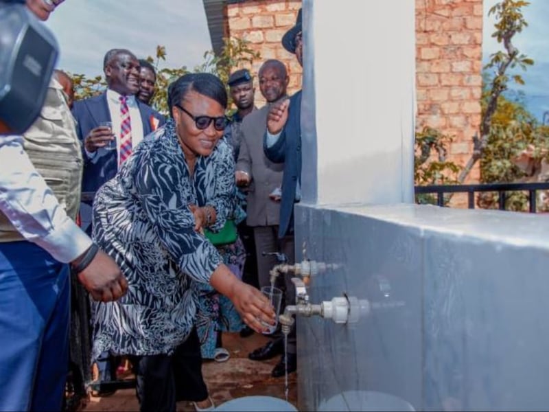 L'adjointe au maire Farida Mwepu Oduel remplit son verre avec l'eau du nouveau puits à la suite de la cérémonie d'inauguration symbolique à Kolwezi, en République démocratique du Congo, le 15 mai 2026.