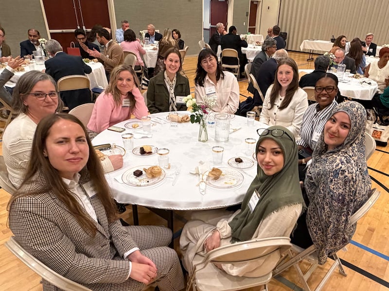 Des femmes sont assises à une table pour partager un repas lors d'un rassemblement interconfessionnel à Chicago (Illinois), le 14 octobre 2026.