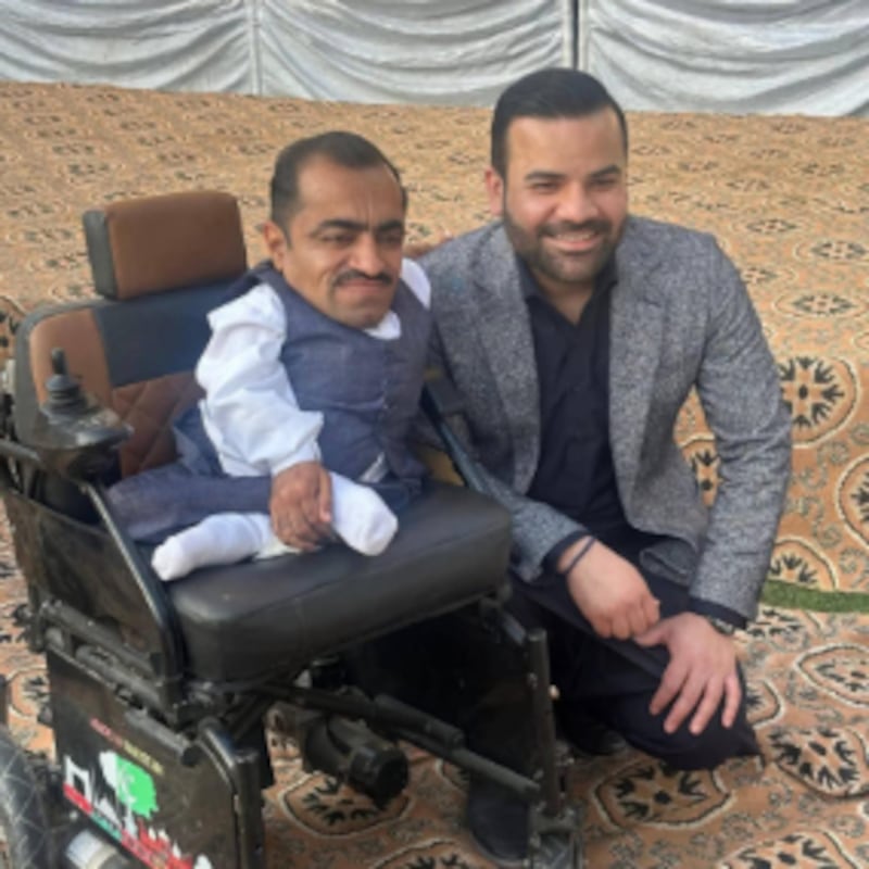 Le ministre d'État du Pakistan, Barrister Aqueel Malik, pose avec le bénéficiaire d'un fauteuil roulant lors d'une cérémonie de remise le 13 février 2026, à Taxila, au Pakistan.
