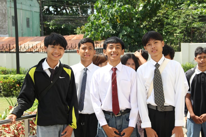 Quatre jeunes hommes assistent aux portes ouvertes du temple de Davao, aux Philippines, le 10 avril 2026.