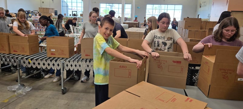 Des jeunes préparent des boîtes de nourriture donnée à la banque alimentaire St. Mary's, à Phoenix, en Arizona, pour la Journée mondiale du service des jeunes, le samedi 18 avril 2026.