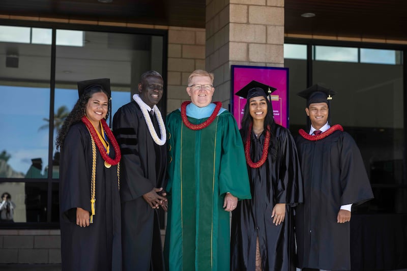 Elder Peter M. Johnson, soixante-dix Autorité générale, deuxième à partir de la gauche, et R. Kelly Haws, président par intérim de BYU–Hawaii, au centre, posent pour une photo avec des diplômés le vendredi 17 avril 2026.