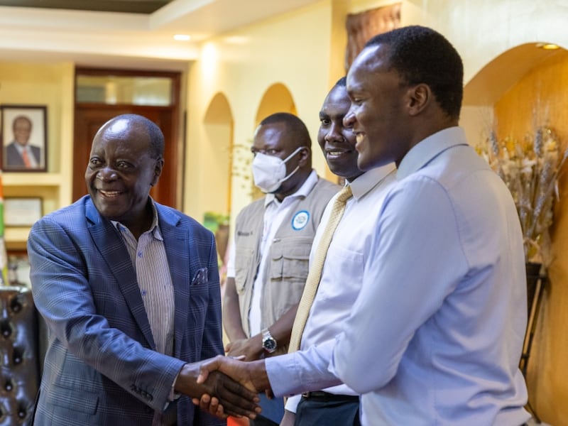 Wilber Ottichilo, gouverneur du comté de Vihiga, au Kenya, à gauche, serre la main de Denis Mukasa, responsable humanitaire de l'interrégion d'Afrique centrale, à droite, le 21 mai 2026.