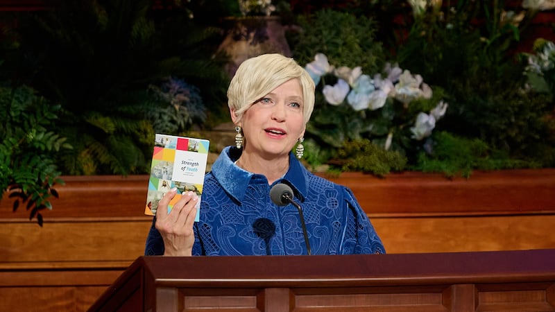 Presidente generale des Jeunes Filles Emily Belle Freeman tient un exemplaire de "Jeunes, soyez forts" alors qu'elle parle lors de la session du dimanche matin de la 196e conference generale annuelle de l'Eglise de Jesus-Christ des Saints des Derniers Jours au Conference Center a Salt Lake City, le 5 avril 2026.