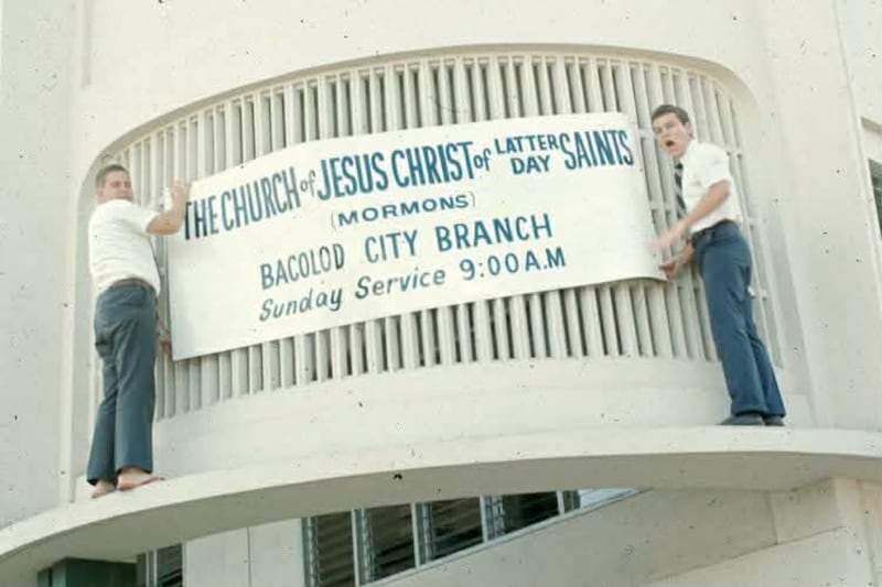 Des missionnaires accrochent une banderole dans un lieu de culte loue dans le batiment Correa, situe a l'angle des rues Araneta et Rosario, l'un des endroits ou les saints des derniers jours se reunissaient pour la reunion de Sainte-Cene dans les annees 1970 a Bacolod City, aux Philippines.