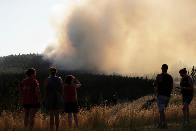 Des gens regardent l'incendie Old Trails depuis le boulevard W. Northwest, le samedi 1er août 2026, à Spokane (Washington).