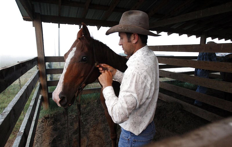 Marshall Godsey bride son cheval alors qu'une journée de travail commence aux Deseret Ranches de Floride en mai 2011.