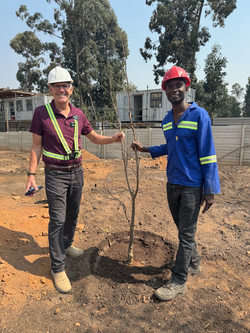 Elder Bruce Anderson et Kilford Shereni se tiennent à côté d'un jeune arbre sur le terrain du temple de Harare, au Zimbabwe.