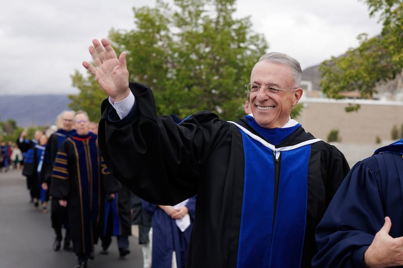 Elder Ulisses Soares, du Collège des douze apôtres, salue la file de diplômés de BYU devant le Marriott Center le jeudi 23 avril 2026, à Provo, en Utah.