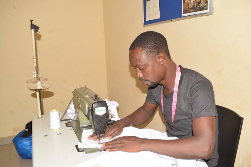 Un tailleur utilise une machine à coudre pour confectionner des vêtements de baptême blancs pour un grand service de baptême comprenant 78 baptêmes à Bamako, au Mali, les 18 et 19 avril 2026.