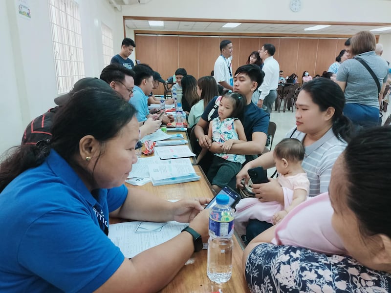 Des parents tiennent leurs enfants au centre de pieu de Pasay, aux Philippines, lors d'un depistage nutritionnel infantile le 18 avril 2026.