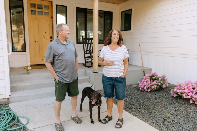 Debout à l'extérieur avec leur chien Mia, Todd et Debbie Rogers racontent comment leur maison a survécu aux incendies de forêt de Spokane, à Spokane (État de Washington), le samedi 22 août 2026.